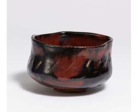 LARGE TEA BOWL (CHAWAN) IN RED BLACK RAKU.  Japan. 19th c.  Brownish stoneware with chamotte with black-red glaze. In the gla