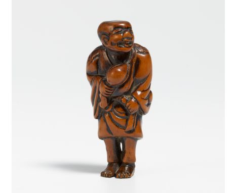 NETSUKE: STANDING TOBOSAKU (DONGFANG SHUO) WITH PEACH AND LEAF COLLAR.  Japan. 19th c.  Boxwood, carved and partly stained da