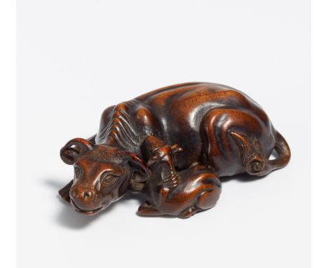 NETSUKE: RECUMBENT COW WITH CALF.  Japan. 1st h. 19th c.  Wood probably shitan, carved and polished. Underneath denoted: Masa