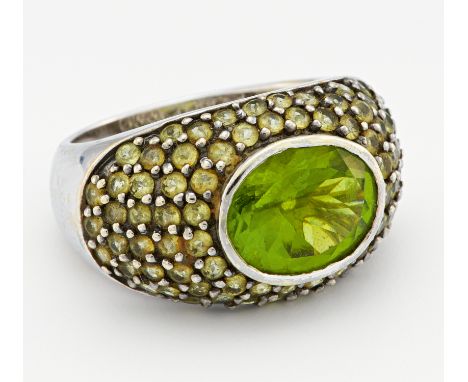 PERIDOT-RING. 585/- Weißgold, Punze, Gesamtgewicht: ca. 8,5 g. EU-RM: 55. Ca. 51 kleine, runde, facettierte Peridots Ø ca. 2,