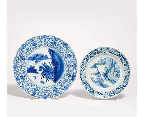 TWO UNDERGLAZE BLUE DISHES WITH LOTOS RIM.  China. Porcelain painted underglaze blue. a) Two gentlemen on horseback hunting f