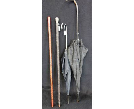 AN INDIAN BLACK EBONY WOOD CARVED WALKING CANE, with unmarked white metal carved top, a red,green & black lacquer cane and tw