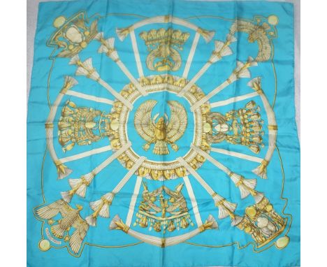 HERMES: A hand rolled silk scarf in sky blue and gold decorated in Egyptian design measuring approximately 86cm square 