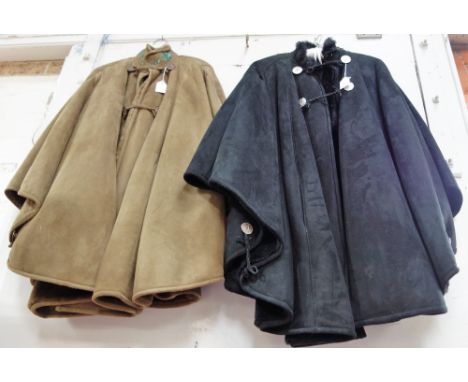 A BLACK SHEEPSKIN CAPE with plaited leather detail and metal button fastening and another in green both by Shearling