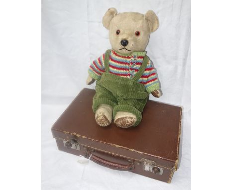 A VINTAGE PLUSH TEDDY BEAR with leatherette pads, sporting a hand-knitted button up jumper and green corduroy trousers, 40 cm