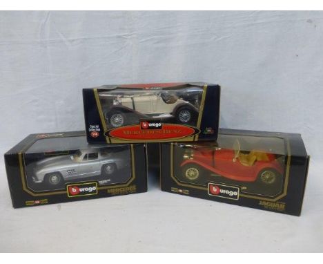 Three boxed Burago 1/18 scale die-cast models including a Jaguar SS 100 (1937), a Mercedes Benz 300 SL (1954) and a Mercedes 