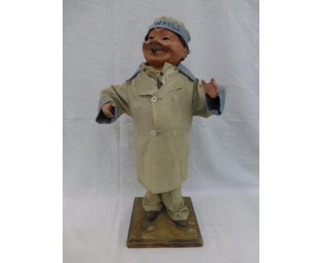 An enamel advertising figure for Walls in the form of a standing man with a tube in his mouth.