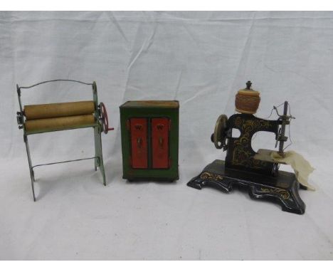 A Remanco miniature tinplate mangle, a similar scale sewing machine and a tinplate money box in the form of a floor standing 