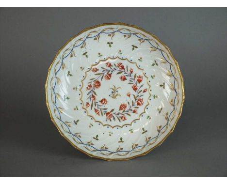 A Caughley bread and butter plate circa 1792 of circular, shanked form decorated in overglaze enamel and gilt, with a circula