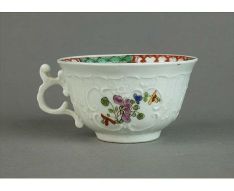 An unusual Worcester teacup circa 1756 of small size with a flared lip and elaborate moulded scroll handle, crisply moulded w