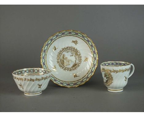 A Caughley tea bowl, coffee cup and saucer circa 1792-1795 each of wrythen moulded form and decorated with gilt wreaths enclo