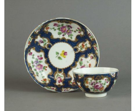 A Worcester 'Blue Scale' tea bowl and saucer circa 1768-72 the bodies reserved with shaped panels painted with flowers in pol