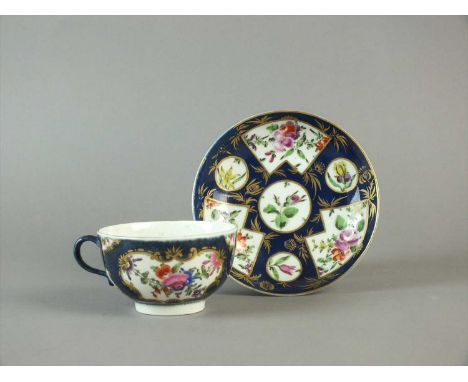 A Worcester blue-scale-ground teacup and a blue-ground saucer circa 1775, The cup painted with gilt-bordered mirror and vase-