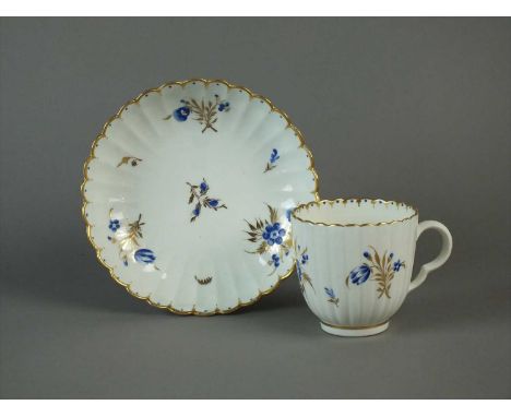 A Caughley coffee cup and saucer circa 1790 of fluted form, painted with anemone blanda and other flowers and supplemantary s