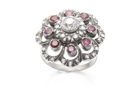 AN ANTIQUE DIAMOND AND RUBY CLUSTER RING in gold and silver, set with a central round cut diamond of 0.30 carats encircled by