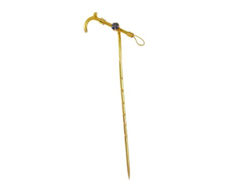 AN ANTIQUE SAPPHIRE RIDING CROP TIE / STICK PIN in 15ct yellow gold, the pin surmounted by a miniature riding crop jewelled w