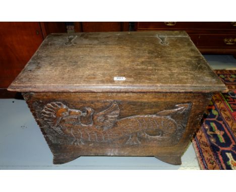 Late 19thC Oak Chest, with a hinged lid, the front panel decorated with a dragon, on out-swept feet, 31”w x 19.5”h