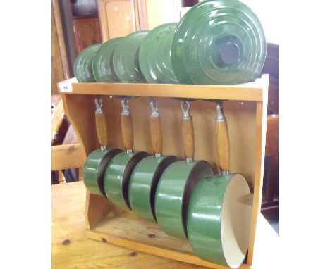 Set of five Le Creuset green enamel sauce pans complete with wall rack 