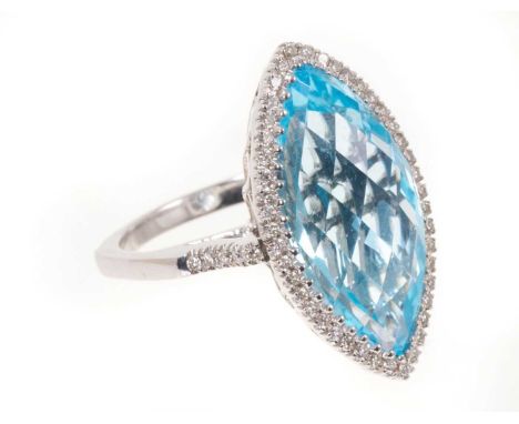 Diamond and blue topaz cluster ring with a marquise shape fancy cut blue topaz measuring approximately 22.5mm x 12mm, surroun