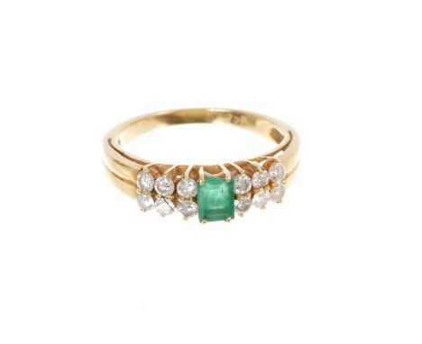 Emerald and diamond ring with a step cut emerald flanked by twelve brilliant cut diamonds on tapered gold shank, stamped 750.