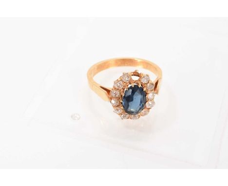Sapphire and diamond cluster ring with an oval mixed cut blue sapphire measuring approximately 8.6 x 6.2mm surrounded by a bo