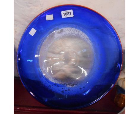 A large art glass dish of flattened form with internal white enamel swirls with blue casing and red rim