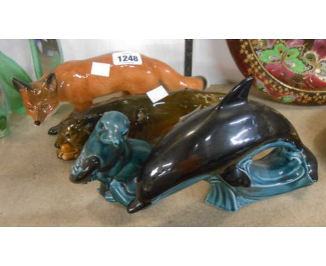 A Poole Pottery blue glazed dolphin figurine and a similar otter - sold with a SylvaC model of a stalking fox and a similar p
