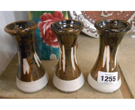 Three Jeremy Leach Studio pottery vases with cut decoration on a tenmoku glaze