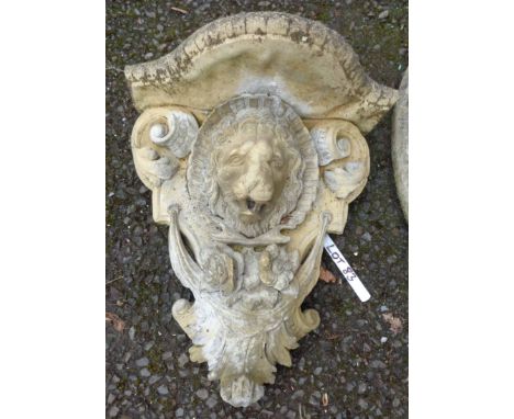 A cast concrete lion mask garden shelf