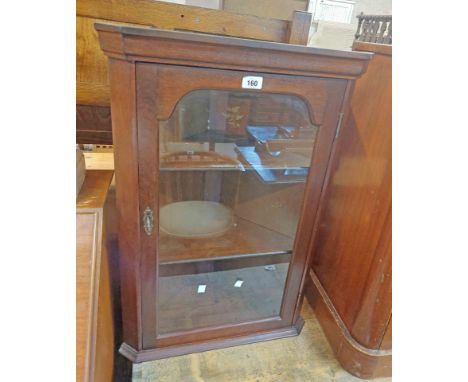 A 52cm 20th Century stained mixed wood wall hanging corner cabinet enclosed by a glazed panel door