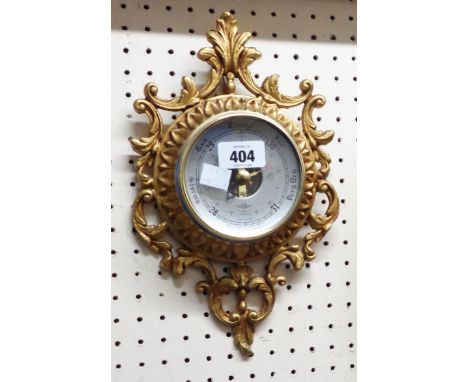 A small gilt metal SB aneroid wall barometer in the cartel style with visible works to dial centre