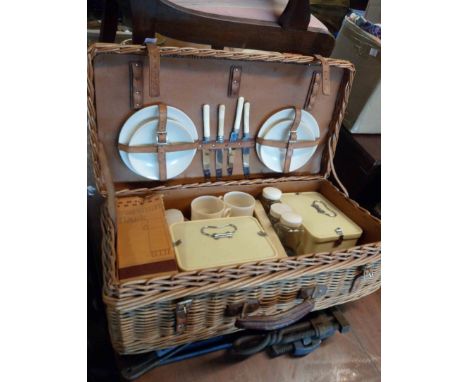 A vintage wicker picnic hamper with fitted contents