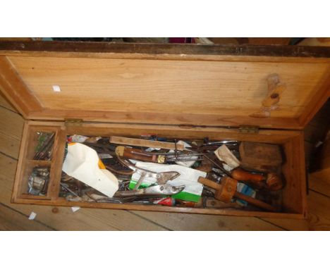 A wooden carpenter's box containing a quantity of assorted tools including scribes, spanners, etc.