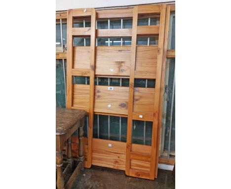 A modern stained pine three shelf folding bookcase