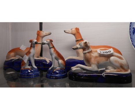 A pair of Staffordshire greyhound inkwell models, a smaller similar and a pair of similar seated greyhounds