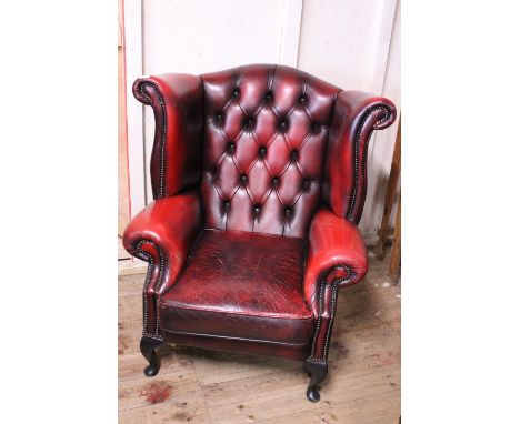 A vintage chesterfield leather wingback armchair in oxblood red. In good condition with general ware and tear. Shipping unava