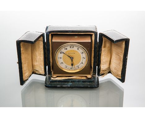 CHARMING BRASS ZENITH TRAVEL ALARM CLOCK
keyless wind movement striking on a bell, the silvered and gilt dial with stylised A