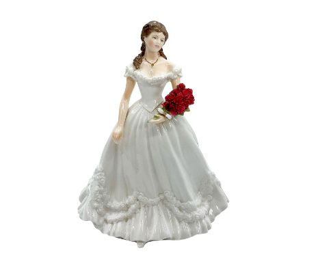 Fine bone china that is the official figurine of the year 2000. Depicts lady in a milk white colored gown with floral pattern