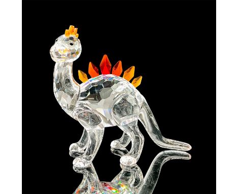 Sparkling clear crystal figure of a little dinosaur with orange scales on his head and back. Item number 268204. Swarovski et