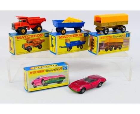 Matchbox - Four boxed Matchbox diecast model vehicles. Lot consists of Matchbox #28 Mack Dump Truck (yellow hubs); #40 Hay Tr
