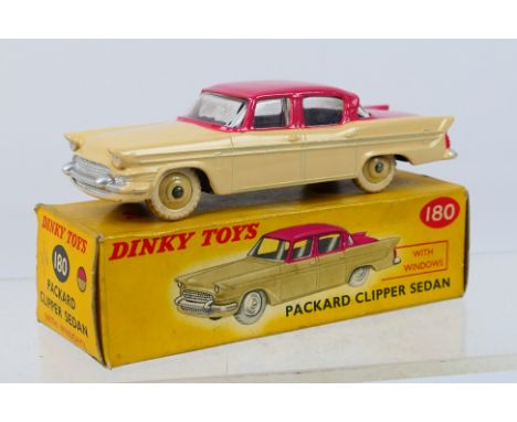 Dinky - A boxed Packard Clipper sedan in cerise over cream # 180. The car appears in Near Mint condition with original white 