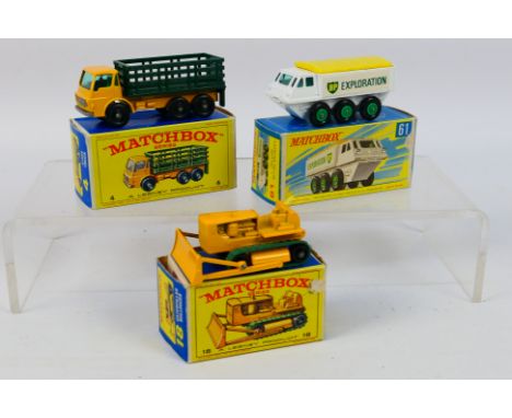Matchbox - Three boxed Matchbox RW diecast model vehicles. Lot consists of Matchbox #4 Dodge Stake Truck; #18 Caterpillar Bul