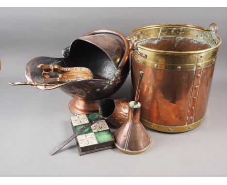 A copper and brass log pail, 13" high, a copper coal scuttle, a pair of copper fire bellows, a copper and brass funnel, a Mid