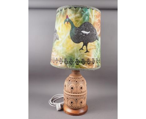 A pierced terracotta table lamp with guinea fowl design shade, 30" overall 