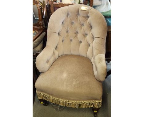 A late 19th century tub-shape armchair, button upholstered in a mushroom velour, on turned and castored supports 