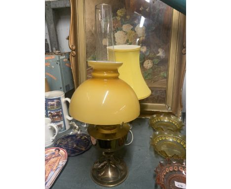 A VINTAGE BRASS OIL LAMP WITH MUSTARD COLOURED GLASS SHADE AND CHIMNEY PLUS A CERAMIC FLORAL TABLE LAMP