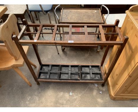 AN EARLY 20TH CENTURY OAK 12 DIVISION STICK STAND WITH 3X4 DIVISION METAL DRIP TRAYS