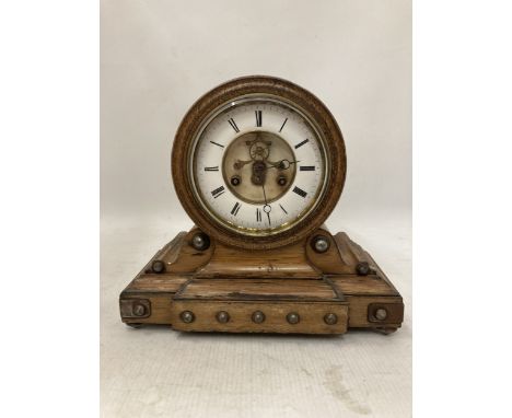 AN OAK WITH STUD DETAIL 8 DAY  DRUMHEAD MANTLE CLOCK WITH ARABIC NUMERALS AND VISIBLE MECHANISM IN THE CENTRE, BELL MOVEMENT 