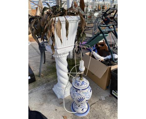 A WHITE CERAMIC JARDINAIRE AND STAND AND A BLUE AND WHITE CERAMIC LAMP
