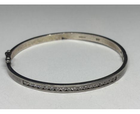 A SILVER BANGLE WITH EIGHTEEN CLEAR STONES